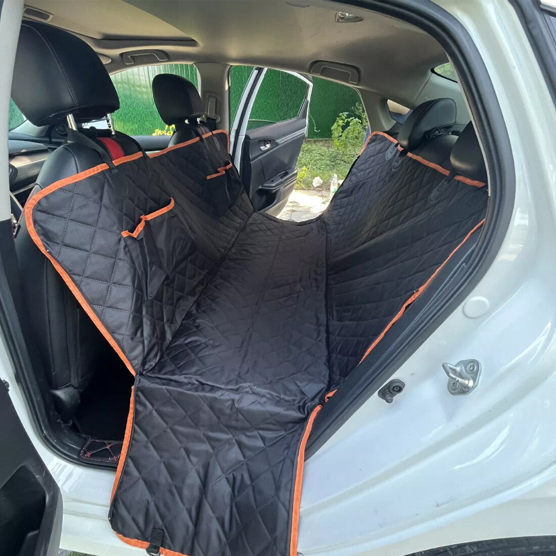 Waterproof dog car seat cover installed as a hammock in a car back seat